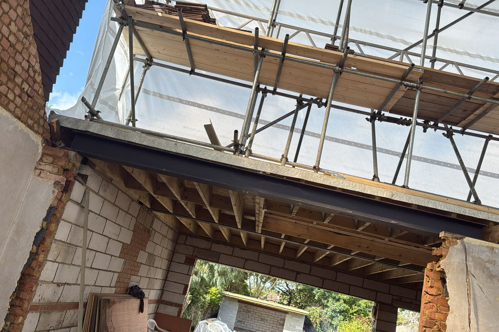 Building under construction with scaffolding and exposed wooden beams.