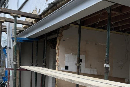 Steel beam installed in load-bearing wall during home extension structural work